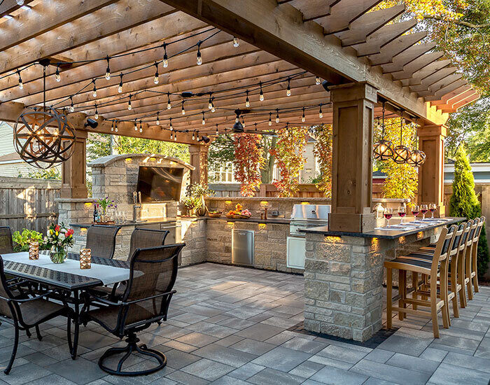 Shaded outdoor kitchen and dining area with string lights